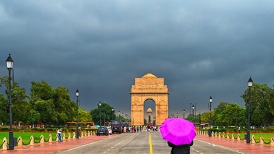 Gram it: Dark, moody clouds loom over Kartavya Path as Delhi catches a refreshing pre-winter chill, signalling the arrival of cooler days ahead. Standing out against the heavy grey skies and the iconic backdrop of India Gate, a lone walker pops open a magenta umbrella, adding a bright burst of colour to the storm-swept stretch. As per the weather forecast, Delhiites can expect partly cloudy skies and a rise in temperature today. (Photo: Vipin Kumar/HT)