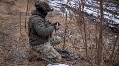 A Ukrainian serviceman prepares a Starlink satellite internet systems at his positions at a front line, amid Russia's attack on Ukraine, near the town of Avdiivka. (Reuters)