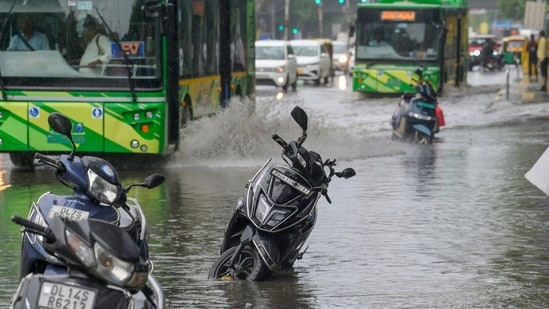 Commuters walk through a waterlogged stretch on Vikas Marg near ITO following heavy rain in New Delhi, India, on Thursday, October 15, 2026. (RAJ K RAJ /Hindustan Times)