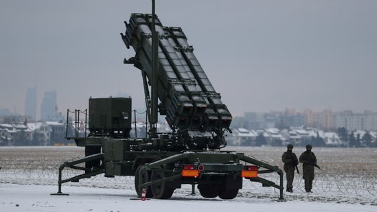 Servicemen patrol in front of the Patriot air defence system during military training, at the airport in Warsaw, Poland.