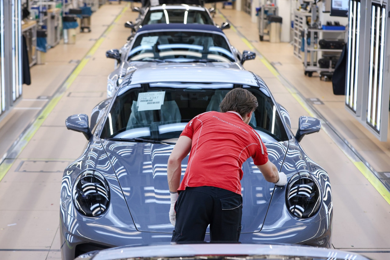 An employee performs a quality check on a Porsche 911 at the end of the assembly line in Stuttgart. An employee performs a quality check on a Porsche 911 at the end of the assembly line in Stuttgart.