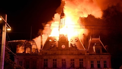 This photograph shows a fire burning and destroying the city hall after a group of individuals forced entry into the building during ongoing protest action against the "high cost of living", in Limoges, central France. (AFP) This photograph shows a fire burning and destroying the city hall after a group of individuals forced entry into the building during ongoing protest action against the "high cost of living", in Limoges, central France. (AFP)
