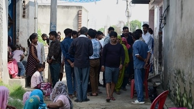 Local residents gather outside the deceased family’s home in a Greater Noida village. (Sunil Ghosh/HT)