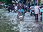 Commuters wade through a waterlogged street following heavy rain, in Chennai, Sunday, Oct. 18, 2026.