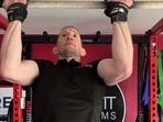 Damien Rooney breaks the Guinness World Record for weighted chin-ups.