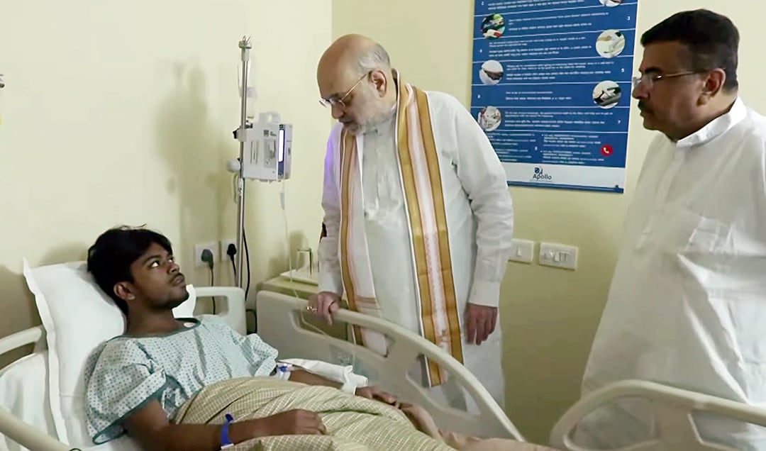 Union home minister Amit Shah and West Bengal Chief Minister Suvendu Adhikari inquire about the health of one of the admitted victims of the Chorbagan Durga Puja pandal stampede at Apollo Hospital in Kolkata. (ANI)