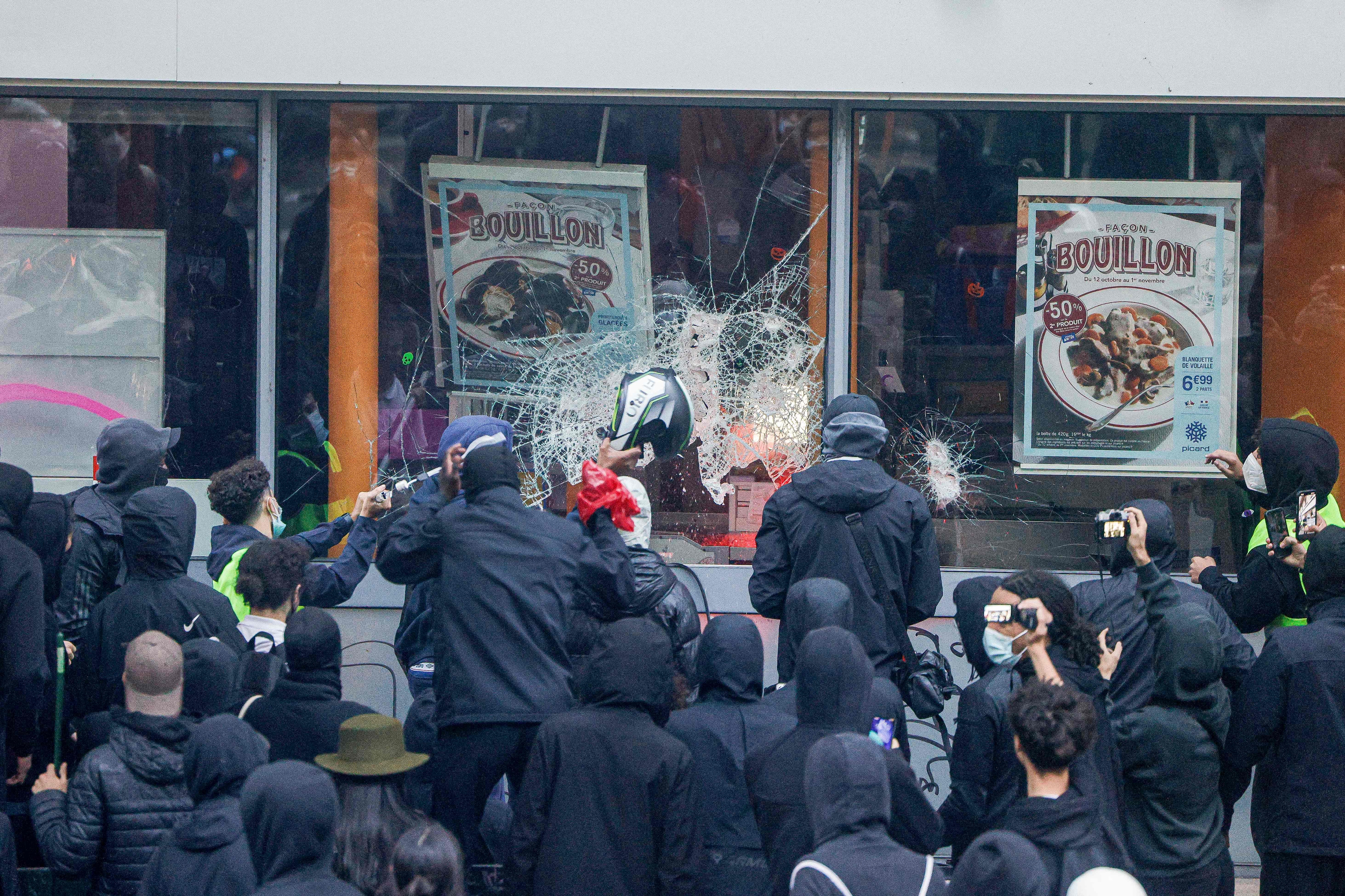 Protesters break windows of a French food company's 'Picard' shop during a demonstration against rising living costs in Paris. (AFP)