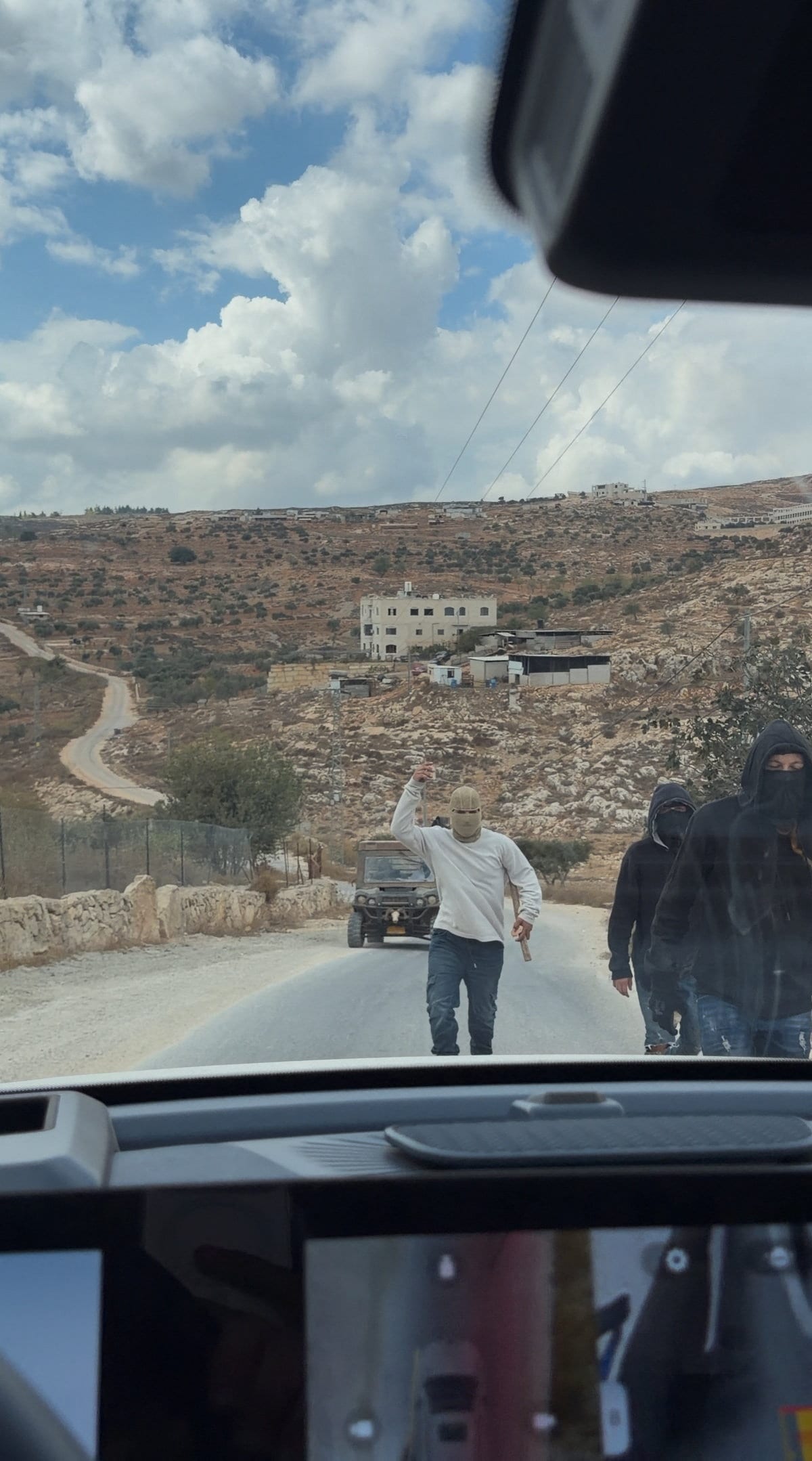 Masked people at the site where Belgium's foreign minister says masked settlers attacked Palestinians, Catholic representatives and Western diplomats and officials, in Taybeh, in the Israeli-occupied West Bank. (Reuters)
