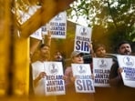 Activists hold placards with slogans reading 'Reclaim Jantar Mantar', 'Rollback SIR', and 'Gyanesh Kumar Must Resign' during a protest march organized by Justice Morcha from the Press Club of India to Jantar Mantar, 