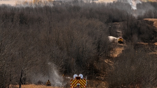 Firefighters working on hot spots, the day after a serious incident that resulted in a fire that caused deaths and injuries, in Wainwright, Alberta, Canada.