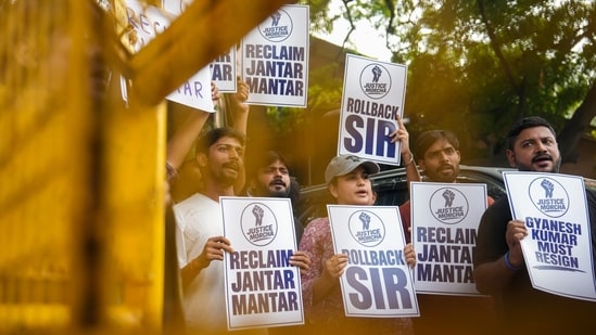 Activists hold placards with slogans reading 'Reclaim Jantar Mantar', 'Rollback SIR', and 'Gyanesh Kumar Must Resign' during a protest march organized by Justice Morcha from the Press Club of India to Jantar Mantar, 