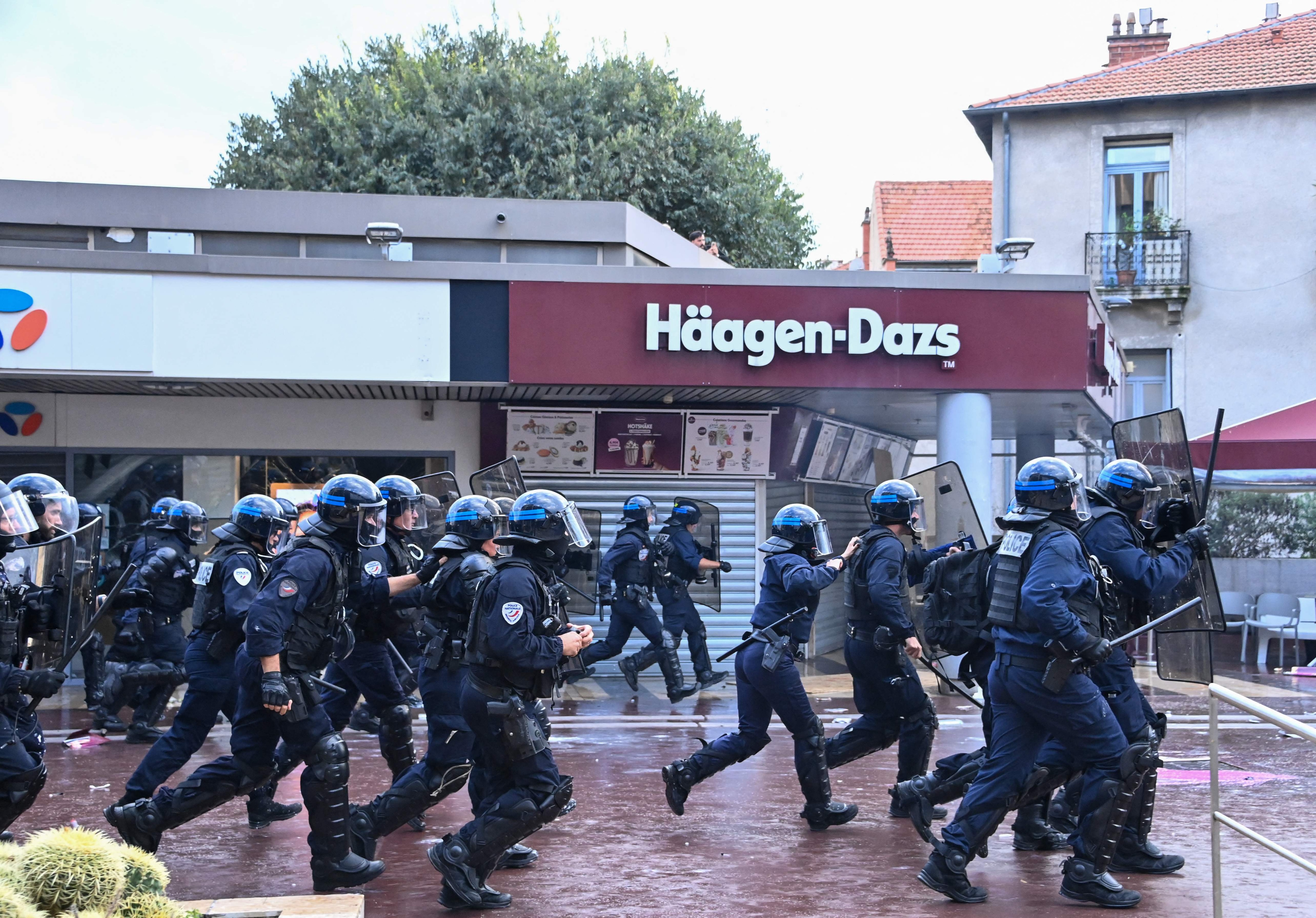 French police officers run toward protesters during a demonstration. (Photo by Sylvain THOMAS / AFP) (AFP)