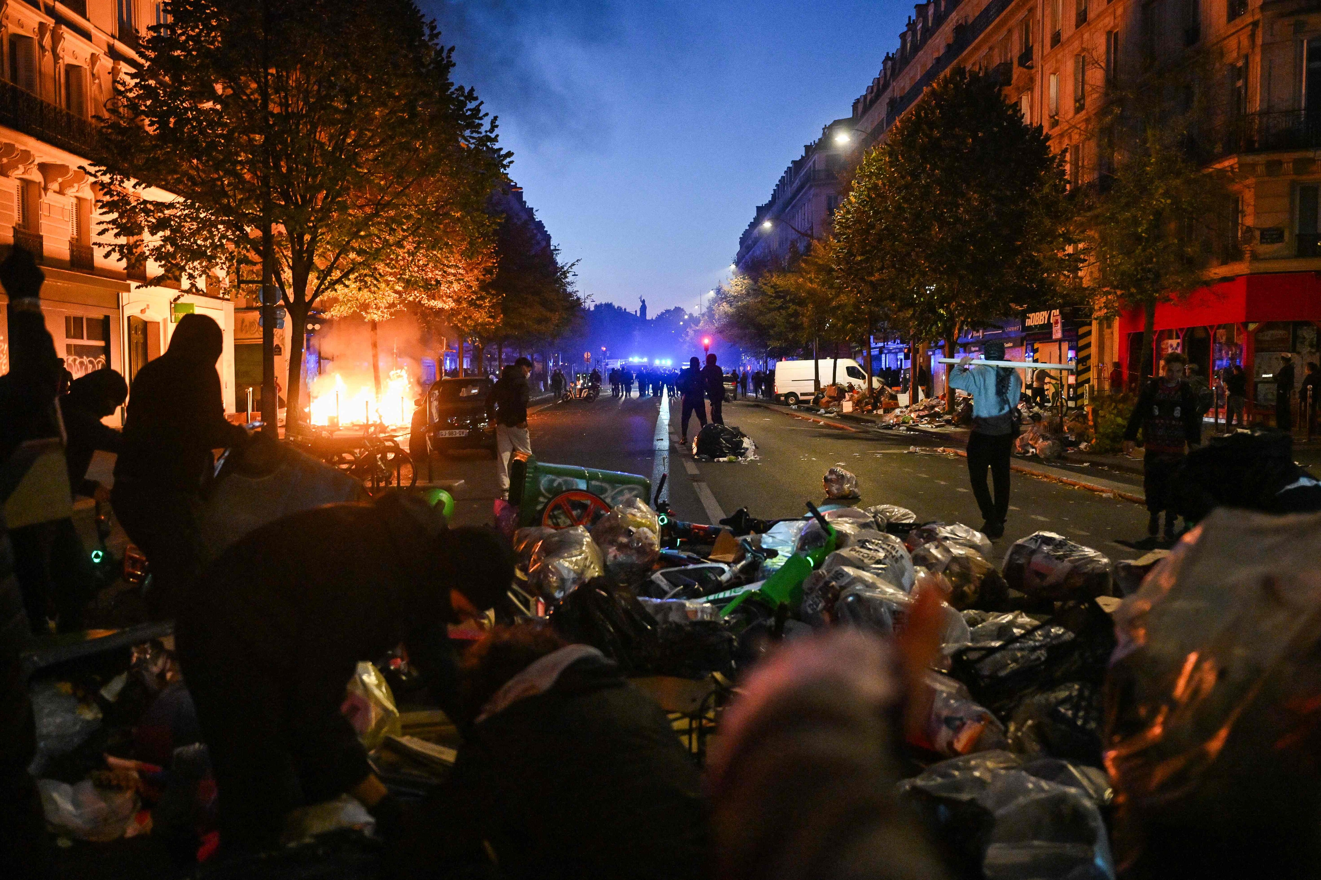 Protestors put objects such as trashes or bike on the Boulevard Voltaire as clashes erupted at Place de la Republique following an unauthorised demonstration, central Paris, on October 18, 2026 a day (Photo by Matthieu RONDEL / AFP) (AFP)