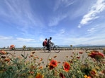 Two men cycle along the road near Sukhna Lake in Chandigarh on Monday. (Ravi Kumar/HT)