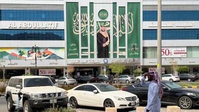 A Saudi man walks past a banner of Saudi Crown Prince Mohammed bin Salman displayed on a commercial building in Riyadh, Saudi Arabia, October 15, 2026. Picture taken with a mobile phone. (REUTERS)