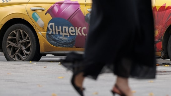 A woman walks past a Yandex-branded car in Moscow, Russia, October 13, 2026. REUTERS/Ramil Sitdikov