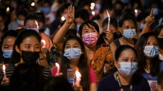 People hold candles as they take part in an anti-coup night protest at Hledan junction in Yangon, Myanmar, March 14, 2021. (REUTERS/Stringer)