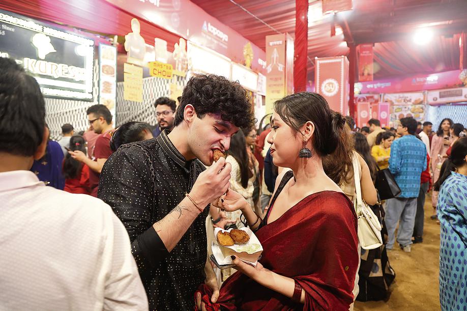Visitors relish vegetable chops at the Co-operative Ground Durga Puja Samity’s pandal