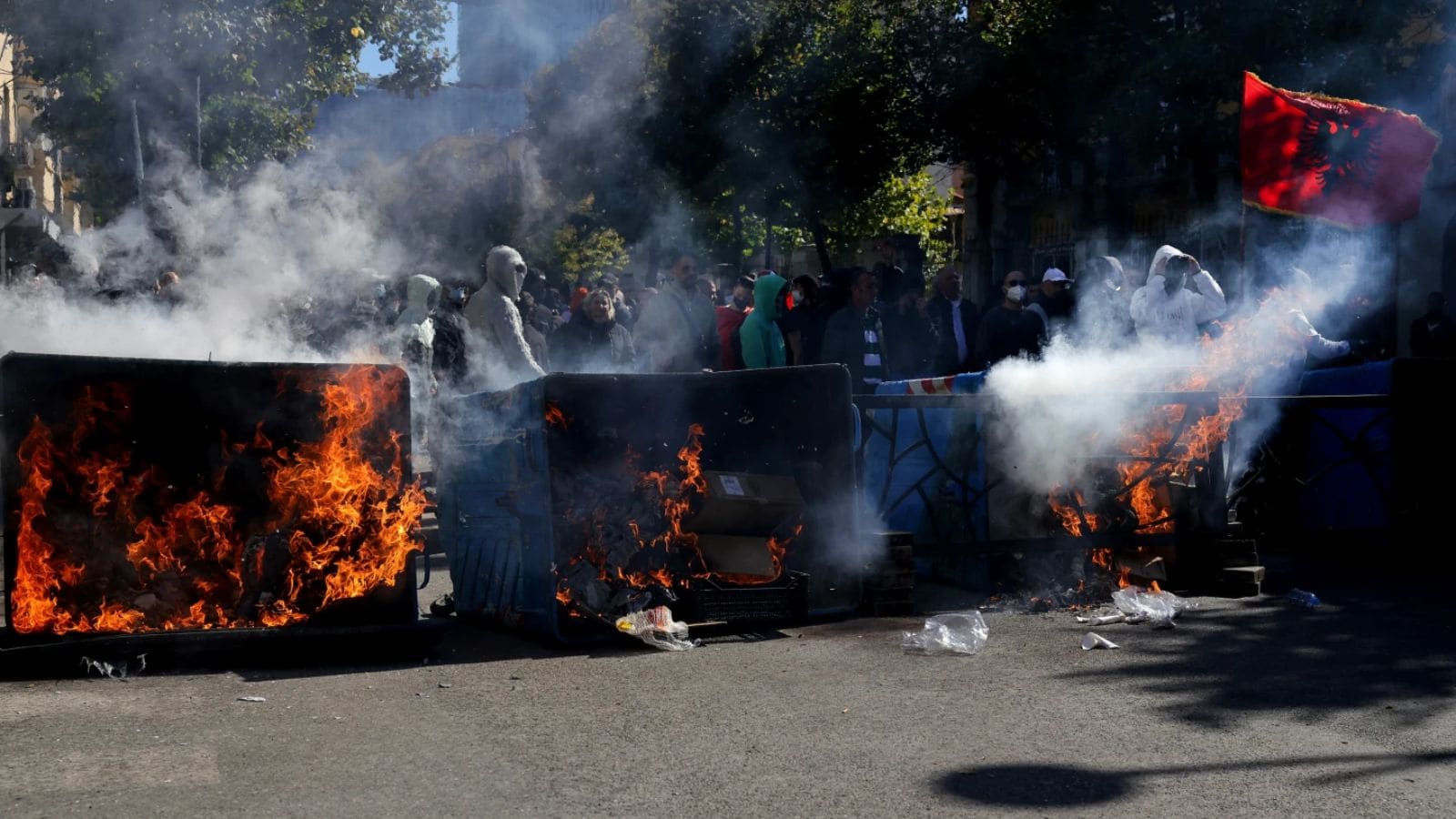 Protesters stand behind burning garbage cans during an anti-government demonstration outside the Education Ministry, in Tirana, Albania, Saturday, Oct. 17, 2026. (AP) Protesters stand behind burning garbage cans during an anti-government demonstration outside the Education Ministry, in Tirana, Albania, Saturday, Oct. 17, 2026. (AP)