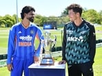 Mitchell Santner (R) and India's Shreyas Iyer pose with the trophy