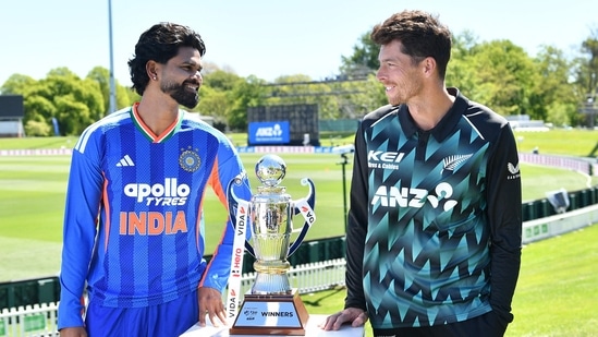 Mitchell Santner (R) and India's Shreyas Iyer pose with the trophy