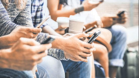 Multicultural friends group using smartphone with coffee at university college break - People hands addicted by mobile smart phone - Technology concept with connected trendy millennials - Filter image (Getty Images/iStockphoto)