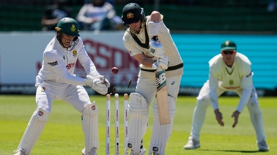 Australia's Steven Smith, centre is bowled out by South Africa's Wiaan Mulder, as South Africa's Ryan Rickelton, left, looks on day four of the second cricket test match between South Africa and Australia, in Gqeberha