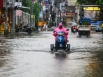 A commuter wearing a raincoat wades through waterlogged General Patters Road amid heavy rainfall, in Chennai on Wednesday. (ANI Photo)