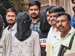Accused persons, arrested for firing at actor Tiger Shroff on Sunday evening, being escorted by police and security personnel after their production at a magistrate court, in Mumbai on Wednesday. (PTI)