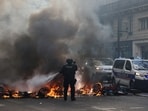 A French police officer extinguishes burning bicycles during a demonstration against the cost of living and rising fuel prices in Paris as part of nationwide protests.