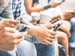 Multicultural friends group using smartphone with coffee at university college break - People hands addicted by mobile smart phone - Technology concept with connected trendy millennials - Filter image (Getty Images/iStockphoto)