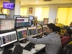 Share brokers track market movements on their computer screens as the Sensex and Nifty. 
