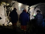 Firefighters inspect an earthquake-hit village houses in Baqen County of Nagqu City in Tibet, on Friday.