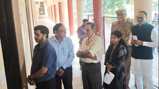Deputy CM Brajesh Pathak standing in queue at Hewett Polytechnic in Lucknow to cast his vote in the UP MLC polls on Friday. (HT)