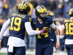Michigan quarterback's Bryce Underwood (19) and Tommy Carr (14) exchange pleasantries during pregame warmups before their NCAA college football game against Indiana in Ann Arbor, Michigan.