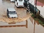 A car wades through a waterlogged street following heavy rainfall near the Ooty bus stand, in Nilgiris on Saturday. (ANI Video Grab) 
