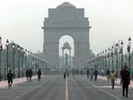 People seen jogging amid morning haze near India Gate in New Delhi on Sunday. (ANI)
