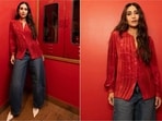 Karisma Kapoor pairs a shimmery red satin shirt with relaxed wide-leg jeans and cream heels.(Instagram/@therealkarismakapoor)