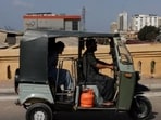 A motorised auto-rickshaw powered by liquefied petroleum gas (LPG) passes a bridge amid rising fuel and LPG prices due to the Iran conflict, in Karachi, Pakistan.(Reuters)