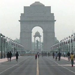 People seen jogging amid morning haze near India Gate in New Delhi on Sunday. 