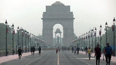 People seen jogging amid morning haze near India Gate in New Delhi on Sunday. (ANI)