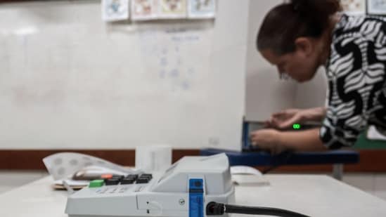 A woman looks at the printed results from a ballot box at a polling station in Jacarepagua, in the southern zone of Rio de Janeiro, Brazil, during the presidential runoff election on October 25.