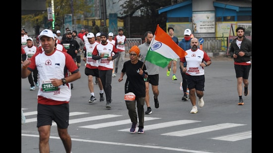 Participant holds the National Flag during the 'Kashmir Marathon in Srinagar on Sunday. (ANI)