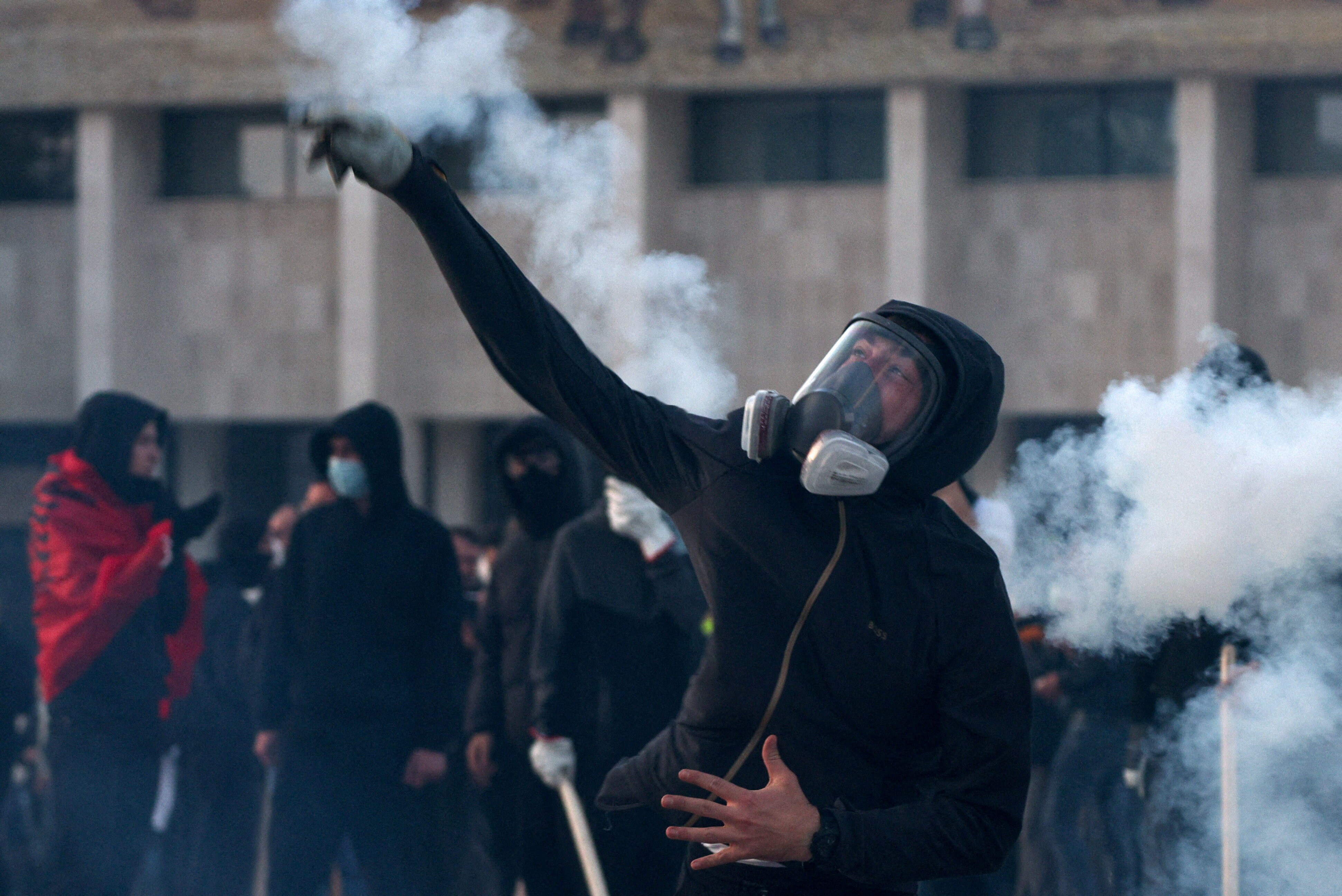 A demonstrator wearing a gas mask throws an object during an anti-government protest by students in Tirana, Albania, October 24, 2026. (REUTERS)