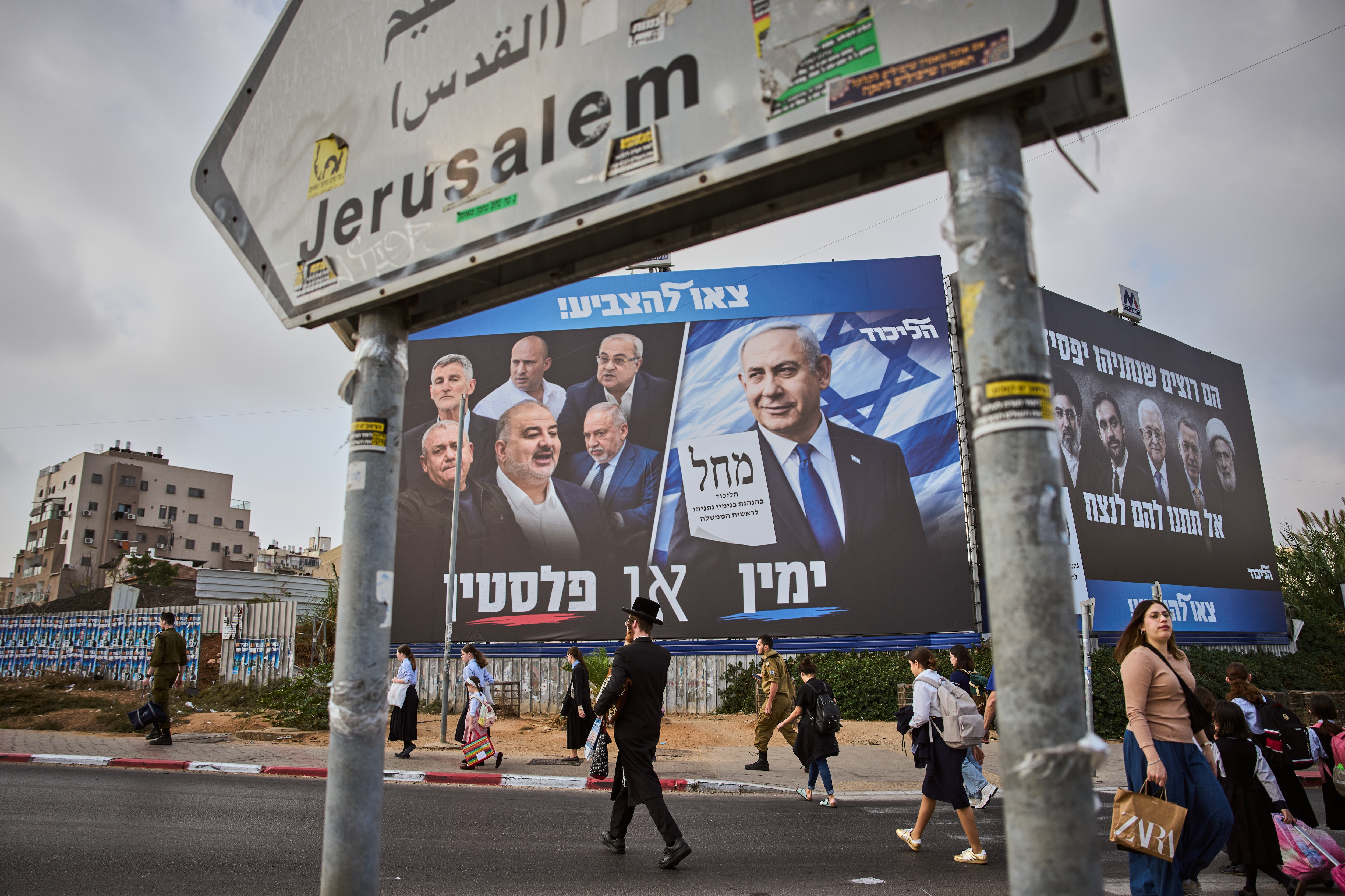 People walk past a Likud party campaign billboard featuring Israeli Prime Minister Benjamin Netanyahu alongside opposition party leaders and bearing the Hebrew slogan "Right or Palestine," ahead of Israel's general election, in Beni Brak, Israel, Sunday, Oct. 25, 2026. (AP Photo/Oded Balilty) (AP Photo) People walk past a Likud party campaign billboard featuring Israeli Prime Minister Benjamin Netanyahu alongside opposition party leaders and bearing the Hebrew slogan "Right or Palestine," ahead of Israel's general election, in Beni Brak, Israel, Sunday, Oct. 25, 2026. (AP Photo/Oded Balilty) (AP Photo)