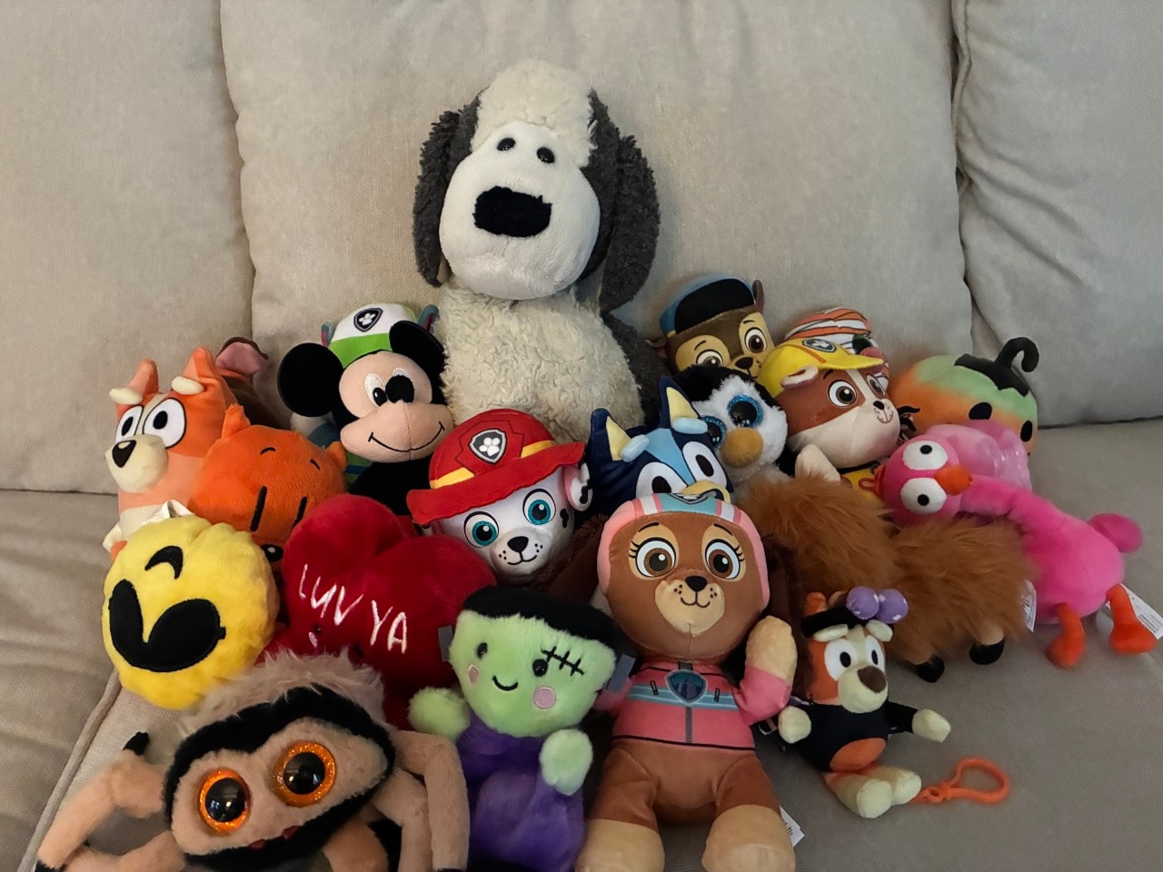 The large plush dog the author's father gave her, with some of her son's stuffies.