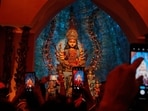 People take photos of an idol of Hindu goddess Durga at a makeshift worship venue on the last day of the festival Durga Puja.(AP Photo/file)