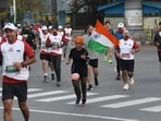 Participant holds the National Flag during the 'Kashmir Marathon in Srinagar on Sunday. (ANI)