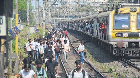 As crowds swelled on platforms and inside trains, several frustrated commuters got down and walked along the tracks to reach nearby stations. (Praful Gangurde / Hindustan Times)