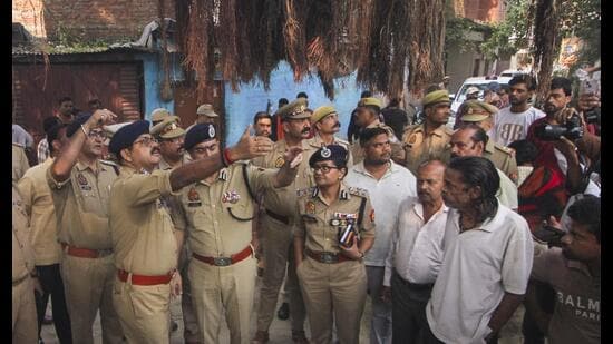 Police personnel inspect the site where three people were killed in a firing incident following a clash over a parking spot in Lucknow on Monday (PTI)